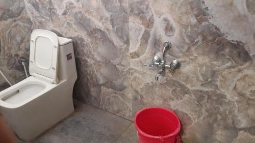 a bathroom with a toilet in a stone wall at MOUNT OASIS RESIDENCY Tiruvannamalai in Tiruvannāmalai