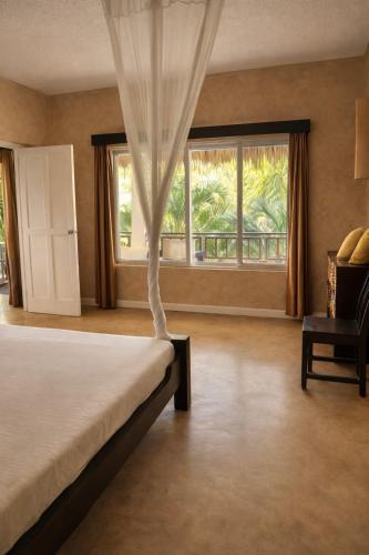 a bedroom with a bed and a large window at Lawford Apartment Malindi in Malindi