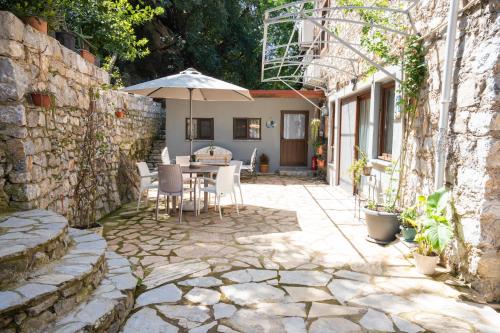 a patio with a table and an umbrella at Beach Suites İçmeler Marmaris in İçmeler