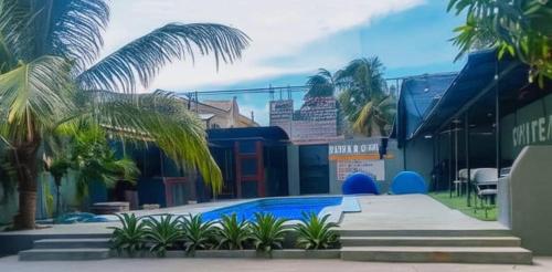 a swimming pool with palm trees in front of a building at Value guests in Magaeline