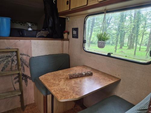 a table and chair in an rv with a window at L insolite in Maxent