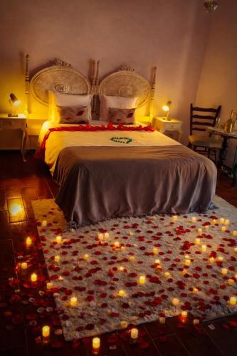 a bedroom with a bed with candles on the floor at Guesthouse Arieira Escapadinha Exclusiva na Natureza in Aguda