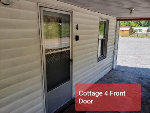 a front door of a house with a red sign on it at Cottage 4 Duplex In Eckman ATV Fun and Rentals! in Northfork