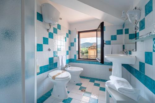 a blue and white bathroom with a toilet and a sink at Albergo Ristorante Locanda Rosella in Giba