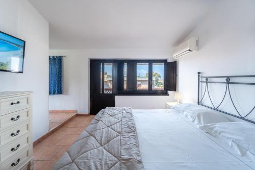 a bedroom with a bed and a dresser and windows at Albergo Ristorante Locanda Rosella in Giba