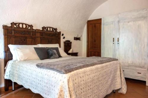 a bedroom with a large bed with a wooden headboard at Casa C'era una volta in Costa Volpino