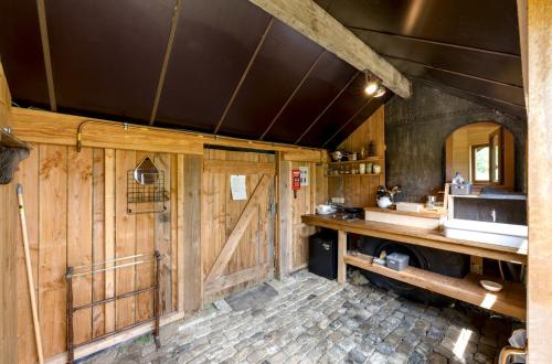 a bathroom with wooden walls and a counter and a sink at Les insolites de la Ferme de Froidefontaine in Havelange