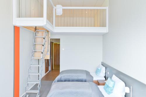 two beds in a small room with a ladder at Aircraft Hotel & Events in Neuhausen ob Eck