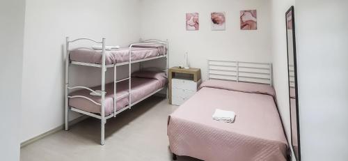 ein Schlafzimmer mit zwei Etagenbetten mit rosa Bettwäsche in der Unterkunft Corte Dolia in Dolianova