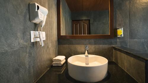 a bathroom with a white sink and a mirror at Sumitel Shangrila in Tādong