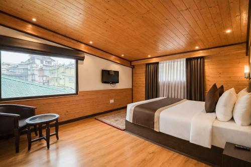 a bedroom with a bed and a large window at Sumitel Shangrila in Tādong
