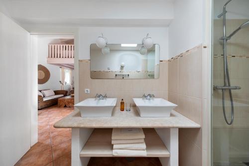 a bathroom with two sinks and a mirror at Casa Flor de Sal in Moncarapacho
