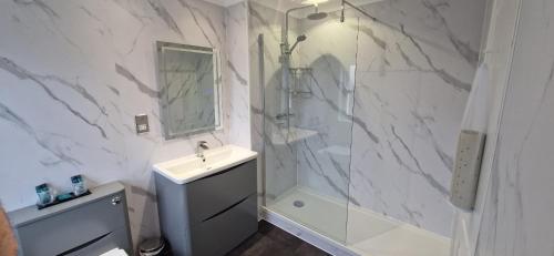 a white bathroom with a sink and a shower at The Royal Hotel in Liverpool