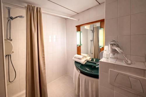 a bathroom with a green sink and a shower at Brit Hotel Calais in Calais