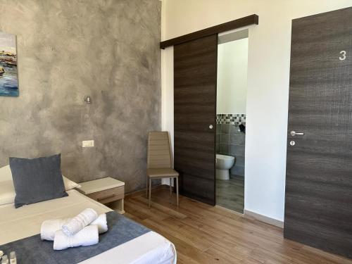 a bedroom with a bed and a bathroom with a toilet at Il vecchio e il mare in San Vito lo Capo