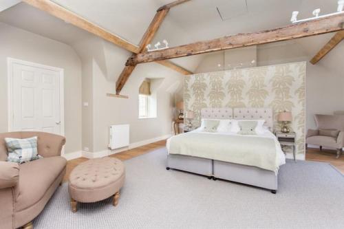 a bedroom with a bed and a couch and a chair at Week Farm Manor in Wellow