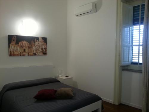 a bedroom with a bed and a picture on the wall at Ai Lattarini House in Palermo