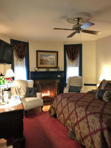 a bedroom with a bed and a fire place at Parsonage Inn Bed and Breakfast in Saint Michaels