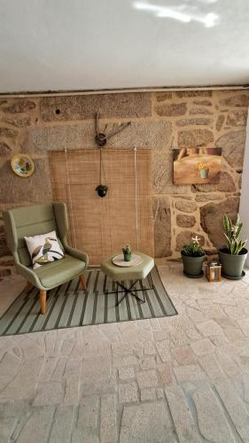 a living room with a chair and a coffee table at Ninho das Andorinhas in Monção