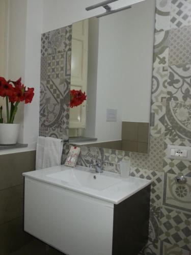 a bathroom with a white sink and a mirror at Ai Lattarini House in Palermo