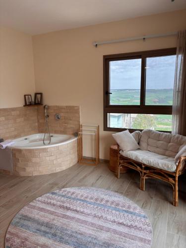 a living room with a bath tub and a couch at sunrise valley - זריחת העמק in Yavneʼel