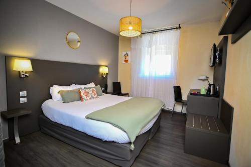 a bedroom with a large bed and a window at Logis Hôtel Le Mas De Jossyl in La Roque-dʼAnthéron