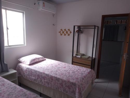 a bedroom with two beds and a window and a mirror at Apartamento in Parnamirim