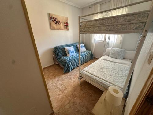 a bedroom with a bunk bed and a couch at BEACH AND CHILL APARTMENT con encanto in Los Alcázares