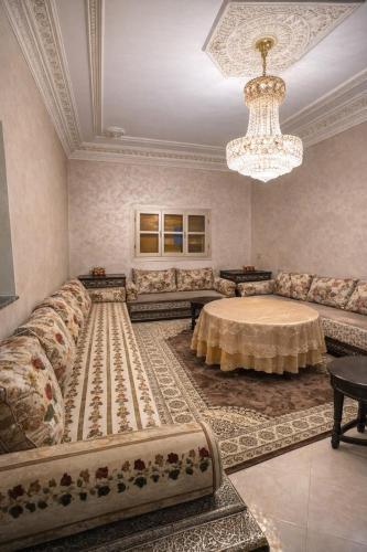 a living room with a large couch and a table at Luxury apartment and duplex in Ouarzazate