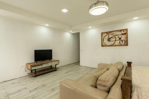 a living room with a couch and a flat screen tv at Catalinas Cozy Room in Fortuna