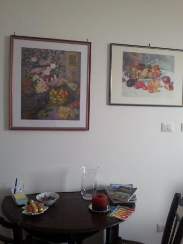 a table with plates of food on it with pictures on the wall at Ai Lattarini House in Palermo