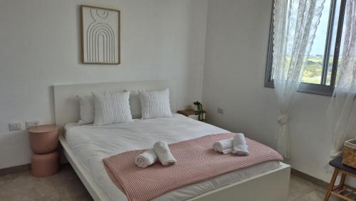 a bedroom with a bed with towels on it at דירת נופש נווה ים in Kefar HaNo‘ar Niẕẕanim