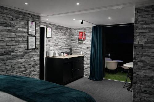 a bedroom with a brick wall and a sink and a tub at Glamping Domes in Articlave