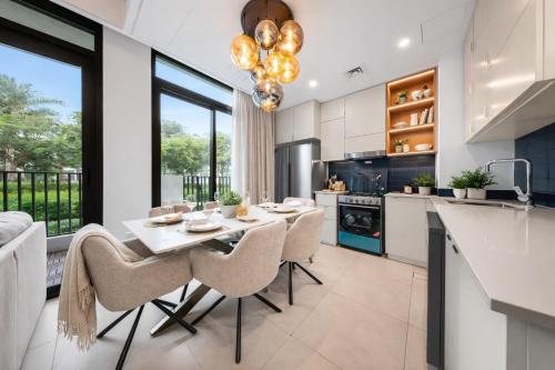 a kitchen and dining room with a table and chairs at DVH Luxe, Elegant 4BR Villa, Gated Resort Amenities, Ranches 3 in Dubai