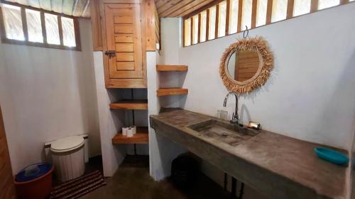 a bathroom with a sink and a mirror at Bungalow Bleu Villa Luna Nosy Be in Nosy Be