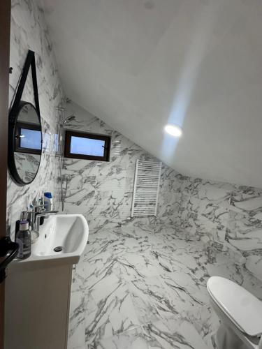 a bathroom with a white sink and a toilet at ng royal in Rakitovo