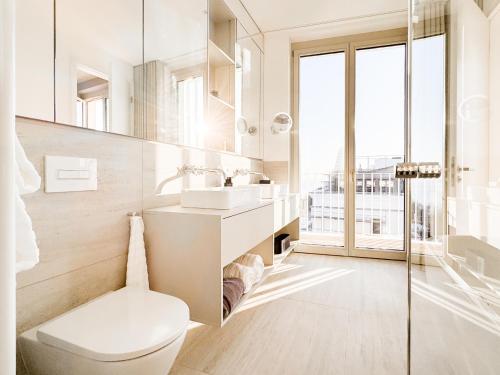 a white bathroom with a toilet and a sink at THE BALTIC VIEW Sellin in Ostseebad Sellin