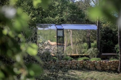 a building with a blue roof next to a stone wall at Designer Cabin With Shared Pool In Bras in Bras