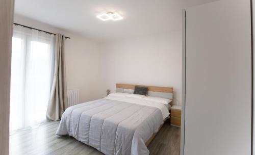a white bedroom with a bed and a window at Casa Serena in Rivarolo del Re ed Uniti