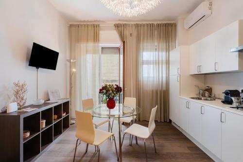 a kitchen and dining room with a glass table and chairs at Mazzini Urban Apartment - Lecce Selection in Lecce