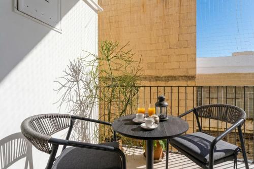 a table with two chairs and drinks on a balcony at Mazzini Urban Apartment - Lecce Selection in Lecce