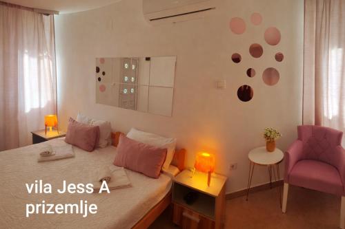 a bedroom with a bed and a pink chair at Vila Konak podno grejanje in Veliko Gradište