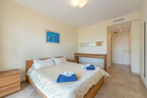 a bedroom with a bed with blue towels on it at Spacious 6-bed Apartment in Marina de la Alcaidesa in La Alcaidesa
