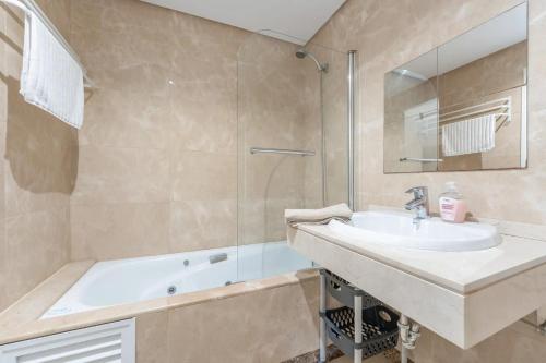 a bathroom with a sink and a bath tub at Spacious 6-bed Apartment in Marina de la Alcaidesa in La Alcaidesa