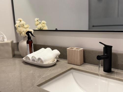 a bathroom counter with a sink and a vase with flowers at 501 First Residences Miami in Miami