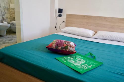 a bed with a blue sheets and a green blanket at Nottata de Luna in San Benedetto del Tronto