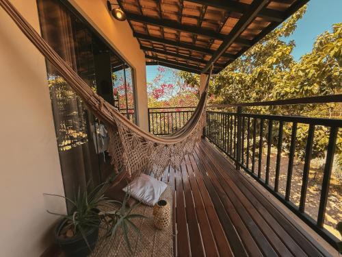 a hammock on the balcony of a house at Claruá Chalés- Loft Caju- Pé direito duplo, 3min de carro do Rio- Conforto e Natureza dentro da cidade in Cavalcante