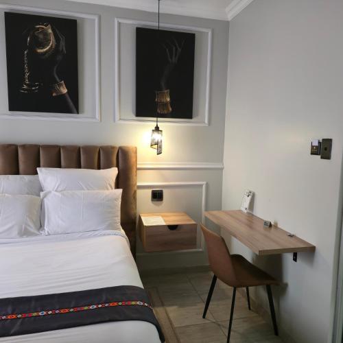 a hotel room with a bed and a desk at Maison Akiba in Pretoria