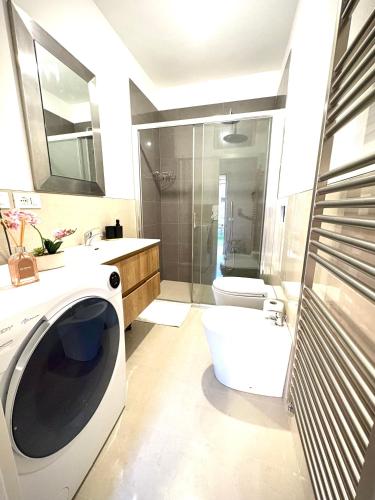 a bathroom with a washing machine and a toilet at Casa in Centro con Giardino in Imola