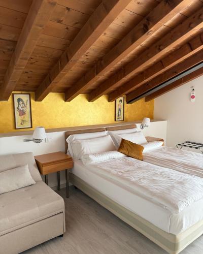 a bedroom with two beds and a wooden ceiling at Hotel Ristorante Miralago in Garda